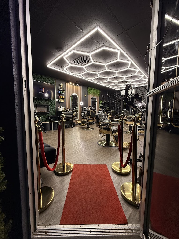 Inside PRAISE Luxury Barbershop — hex LED ceiling, gold stanchions, and red ropes at grand opening